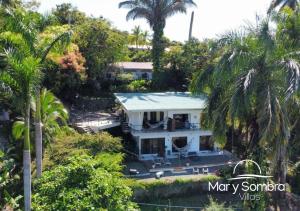 an aerial view of a white house with palm trees at Mar y Sombra Villas in Quepos