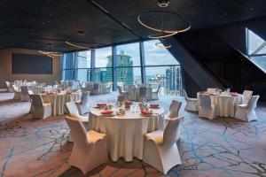 a banquet hall with white tables and chairs and windows at Element Kuala Lumpur in Kuala Lumpur