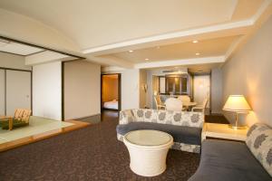Mikawawan Resort Linx في Nishio: غرفة معيشة مع أريكة وطاولة