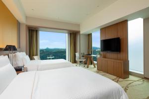 um quarto de hotel com duas camas e uma televisão de ecrã plano em The Westin Sendai em Sendai