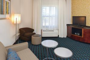 a living room with a couch and a chair and a television at Fairfield Inn & Suites Santa Maria in Santa Maria