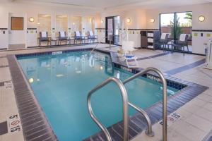 a pool in a hotel with chairs and tables at Fairfield Inn & Suites Santa Maria in Santa Maria
