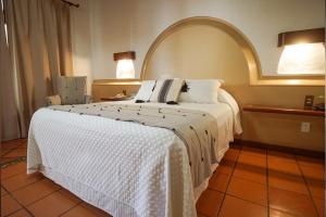 ein Schlafzimmer mit einem großen Bett mit einer weißen Decke in der Unterkunft Hotel Casa Vertiz in Oaxaca de Juárez