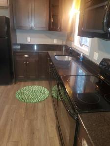 a kitchen with wooden cabinets and a green rug on the floor at Adorable 1 bedroom with off-street parking 