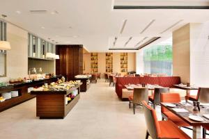 a dining room with tables and chairs and a restaurant at Fairfield by Marriott Kathmandu in Kathmandu
