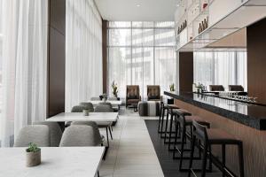 a restaurant with tables and chairs and windows at AC Hotel by Marriott Little Rock Downtown in Little Rock