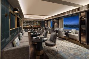 a restaurant with couches and tables and a bar at Indore Marriott Hotel in Indore