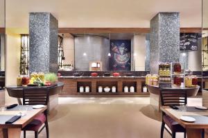 a restaurant with tables and chairs and a bar at Courtyard by Marriott Chennai in Chennai