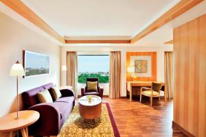 a living room with a couch and a table at Courtyard by Marriott Chennai in Chennai