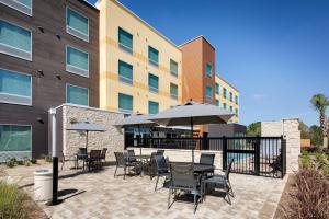 a patio with tables and chairs and umbrellas in front of a building at Fairfield Inn & Suites by Marriott Tampa Wesley Chapel in Wesley Chapel