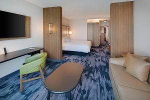 Habitación de hotel con cama y sofá en Fairfield Inn & Suites by Marriott Tampa Wesley Chapel, en Wesley Chapel