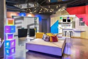 a living room with a couch and a kitchen at Aloft Denver North Westminster in Westminster
