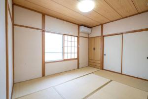 an empty room with white walls and a wooden ceiling at コーポセキヤ / Corp Sekiya in Itoigawa