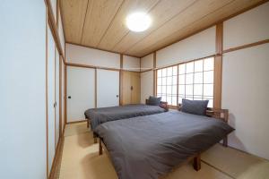 two twin beds in a room with a window at コーポセキヤ / Corp Sekiya in Itoigawa