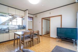 a kitchen with a table and chairs and a television at コーポセキヤ / Corp Sekiya in Itoigawa