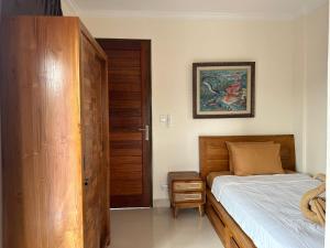 - une chambre avec un lit et un placard en bois dans l'établissement Adipana Bungalow-Balinese Room, à Ubud