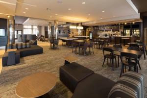 a hotel lobby with tables and chairs and a bar at Courtyard Bay City in Bay City