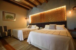 a bedroom with two beds and a window with lights at Hotel Casa Vertiz in Oaxaca City