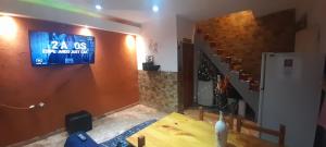 uma sala de jantar com uma televisão na parede e uma mesa em Alojamiento walter em Ezeiza