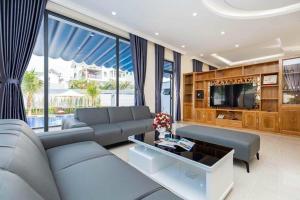 ein Wohnzimmer mit Sofa und Fernseher in der Unterkunft Luxury Chilinh - Large Swimming Pool - 200M To The Sea in Vũng Tàu