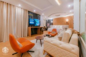 Arabella Residence في القاهرة: غرفة معيشة بها أريكة وكراسي وتلفزيون
