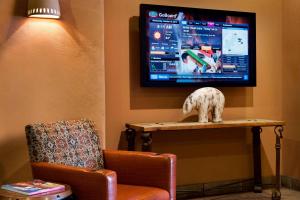 a living room with a chair and a tv at Courtyard Page at Lake Powell in Page