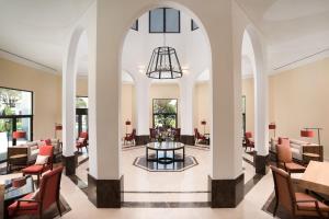 a lobby with chairs and tables and a chandelier at Pine Cliffs Ocean Suites, a Luxury Collection Resort & Spa, Algarve in Albufeira