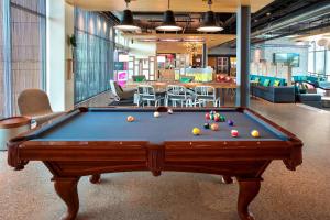 a pool table in the middle of a room at Aloft Buffalo Airport in Cheektowaga