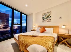 a bedroom with a large bed with a large window at Highrise view 1king1Queen 2baths in Melbourne