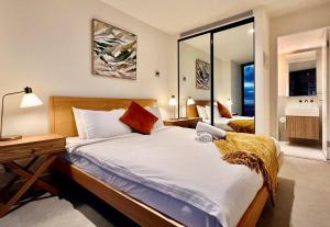 墨尔本Highrise view 1king1Queen 2baths的一间卧室配有一张带书桌和镜子的床
