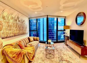 a living room with a couch and a television at Highrise view 1king1Queen 2baths in Melbourne