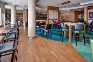 a lobby with tables and chairs and a restaurant at SpringHill Suites by Marriott Wichita Airport in Wichita