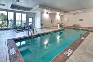 a swimming pool with blue water in a building at SpringHill Suites by Marriott Wichita Airport in Wichita