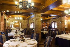 a restaurant with white tables and chairs and a chandelier at AC Hotel Almería by Marriott in Almería