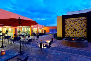 a patio with tables and chairs and a fire pit at Courtyard Toluca Tollocan in Toluca