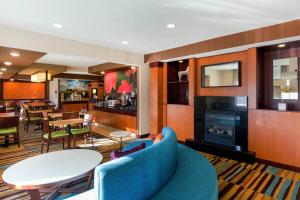 a living room with a blue couch and a fireplace at AmericInn by Wyndham St Cloud MN Shopping Area in Saint Cloud