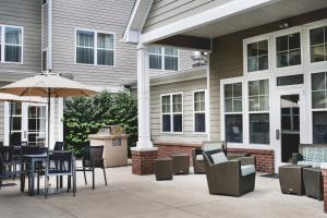 a patio with chairs and tables and an umbrella at Residence Inn Paducah in Paducah