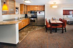 a kitchen with a table and a room with a bed at Residence Inn Paducah in Paducah