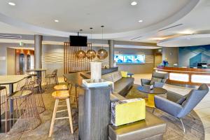 eine Lobby eines Hotels mit einer Bar und Stühlen in der Unterkunft SpringHill Suites By Marriott Columbia Fort Meade Area in Columbia