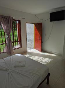 1 dormitorio con 1 cama y puerta con ventana en Hospedaje villa luz en Pitalito