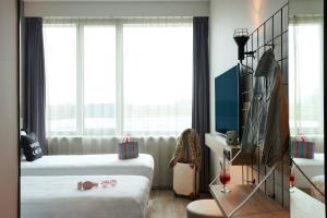 una camera d'albergo con due letti e una finestra di Moxy Amsterdam Schiphol Airport a Hoofddorp