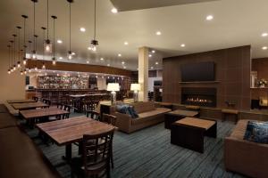 un restaurante con mesas y un bar con chimenea en Delta Hotels by Marriott Helena Colonial, en Helena