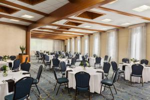 um salão de banquetes com mesas e cadeiras brancas em Delta Hotels by Marriott Helena Colonial em Helena