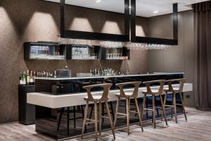 a bar in a restaurant with stools at a counter at AC Hotel Bologna by Marriott in Bologna