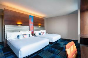 a hotel room with two beds and a chair at Aloft Boston Seaport District in Boston