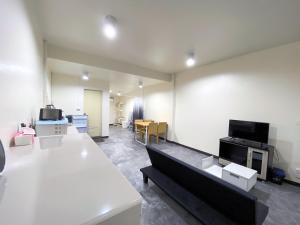 清邁的住宿－Studio townhouse near Airport and old town Chiang Mai，一间带白色墙壁的客厅和一间带电视的客房。