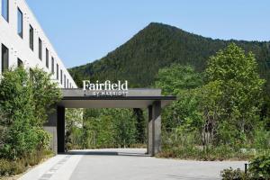 a sign over a road with a mountain in the background at Fairfield by Marriott Tochigi Nikko in Nikko