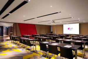 a conference room with tables and chairs and a screen at Aloft Taipei Beitou in Taipei