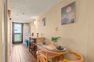a dining room with a table and chairs and a kitchen at Cozy & Charming Oceanfront Condo #803 @ Buena Vista in Myrtle Beach