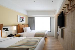 京都的住宿－Moxy Kyoto，酒店客房设有两张床和窗户。